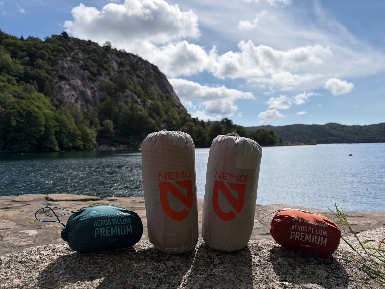 Two NEMO Tensor All-Season mats packed down beside two Sea to Summit Aeros Premium pillows by the water